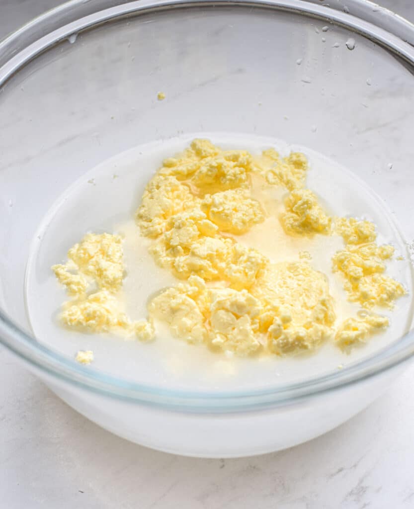 a bowl of butter clumps in water