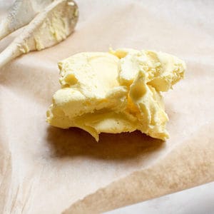 A picture of a clump of cultured butter on a bench that was made using a guide on how to make cultured butter.