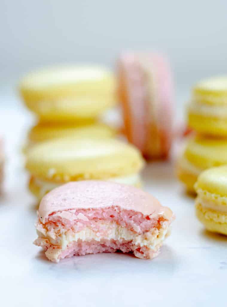 A pink macaron with a bite out of it