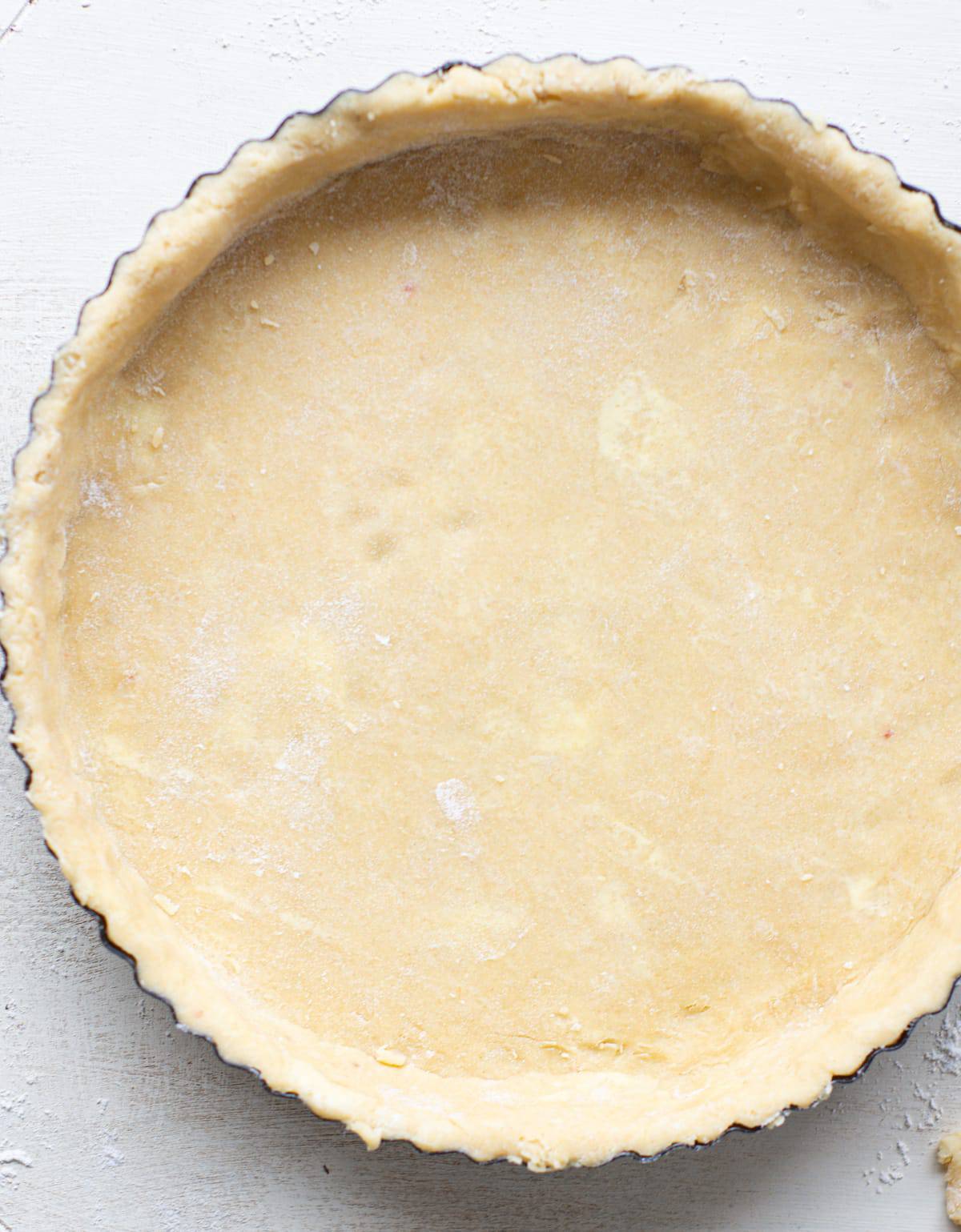 a tin of unbaked pastry in a tart pan