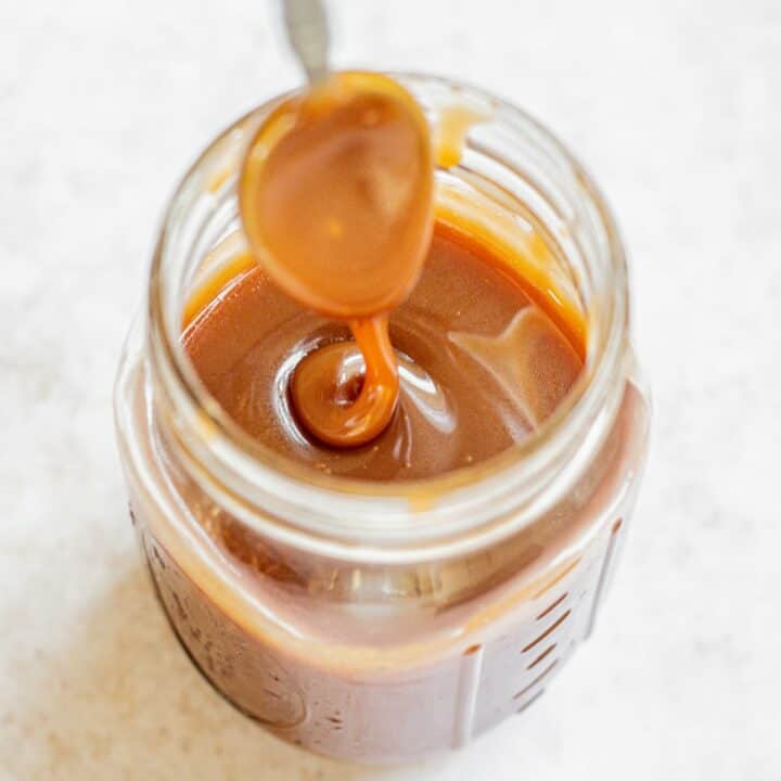 a jar of caramel sauce with a spoon.