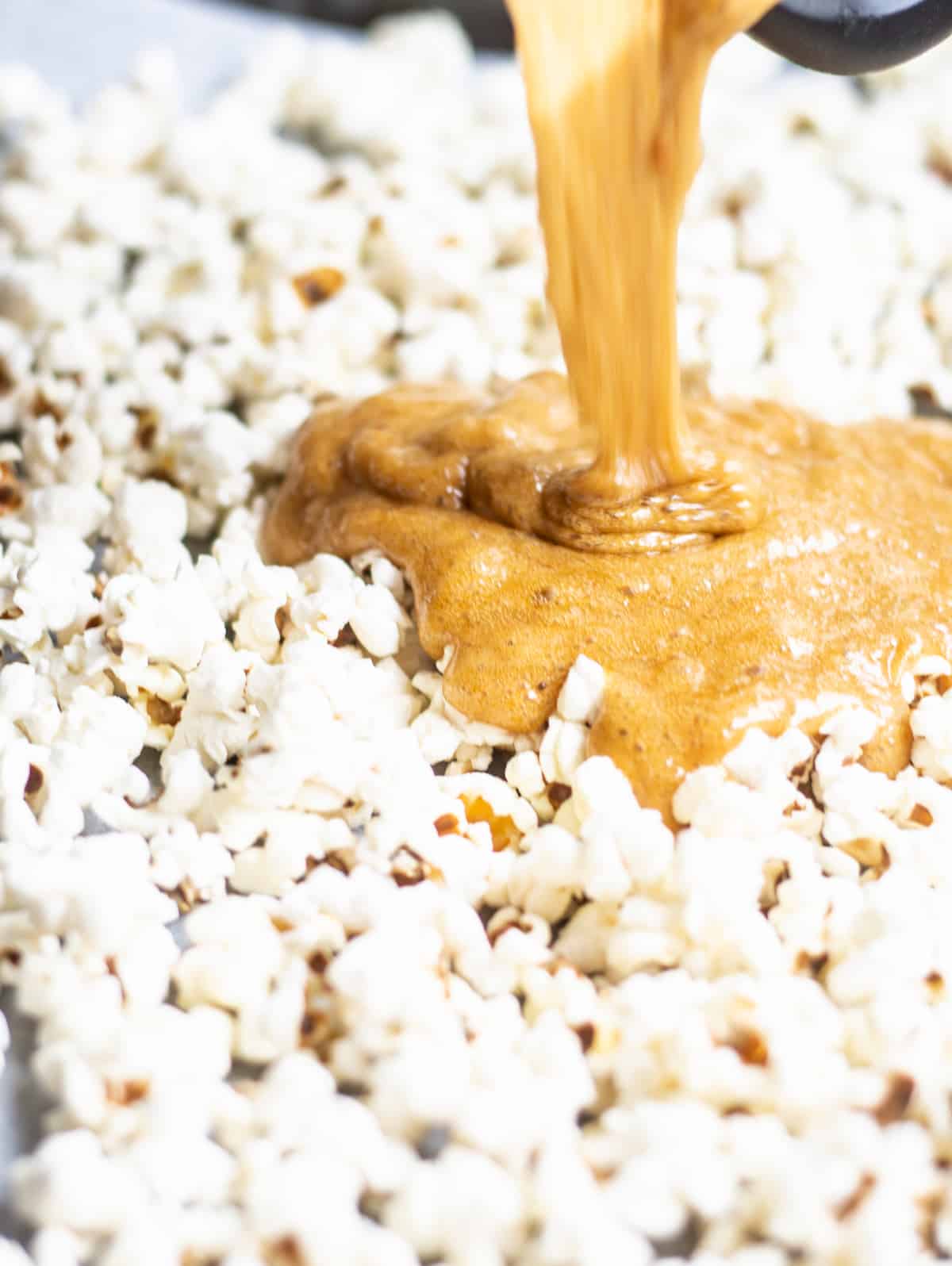 caramel being poured over popcorn
