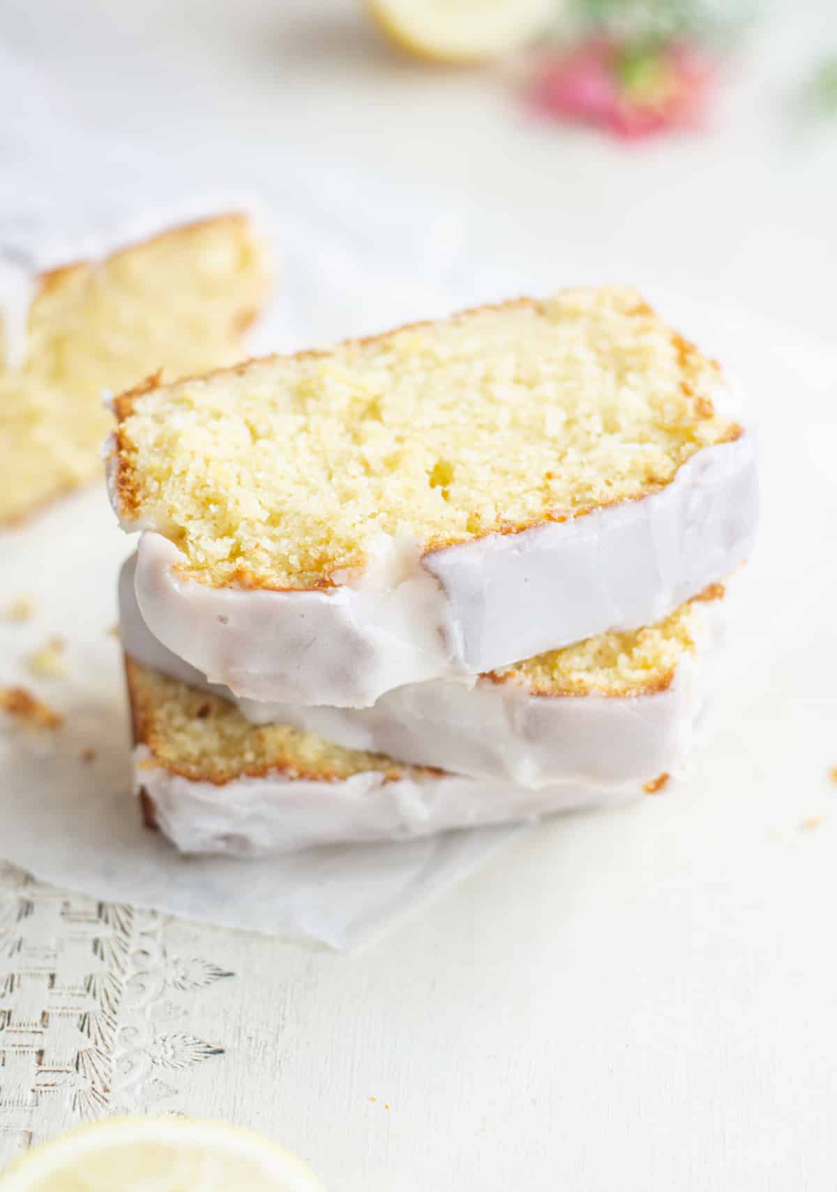 stacked lemon loaf slices with white icing flowers in the background