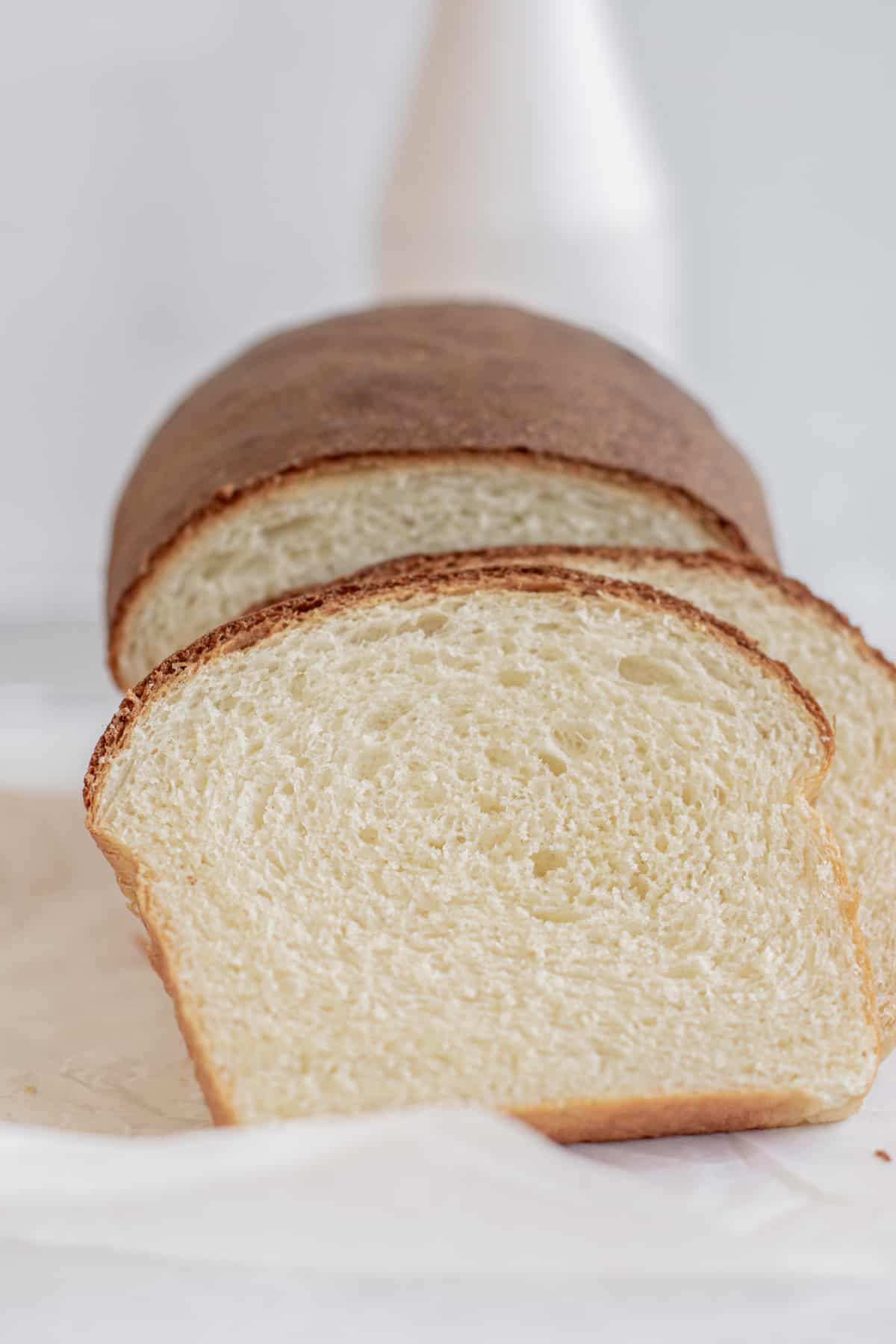 Beautiful condensed milk bread that has been beautifully sliced on a bench. 