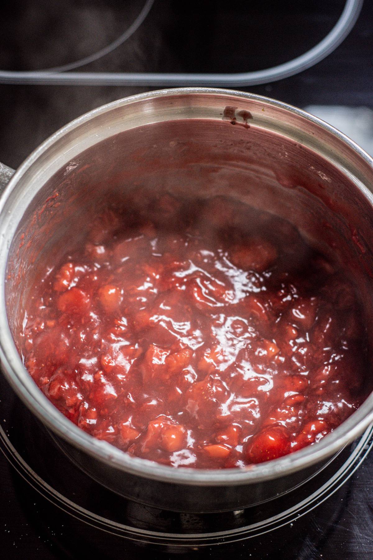 Strawberry filling being cooked in a pan.