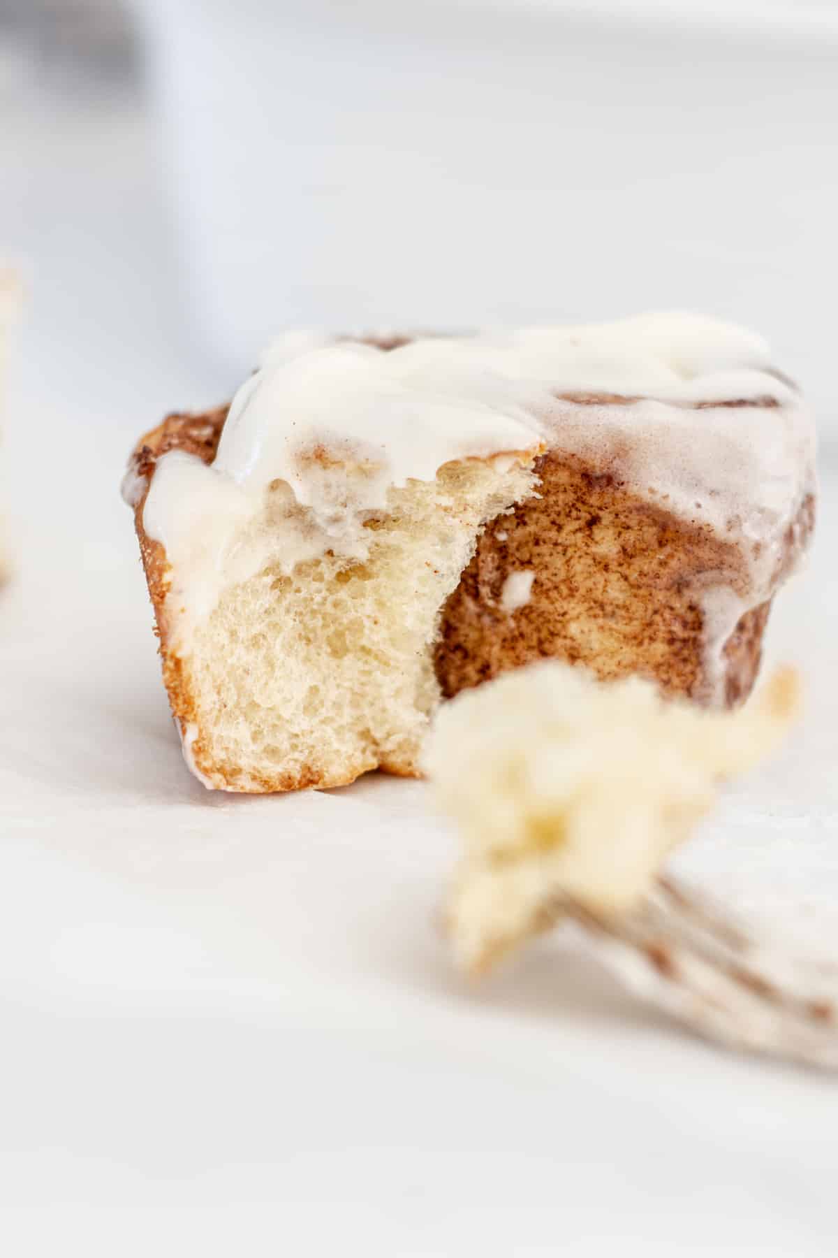 Close up of a cinnamon roll without eggs and cream cheese icing.