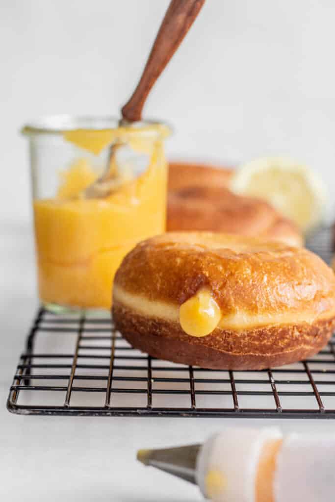 a filled donut with a little lemon curd coming out.