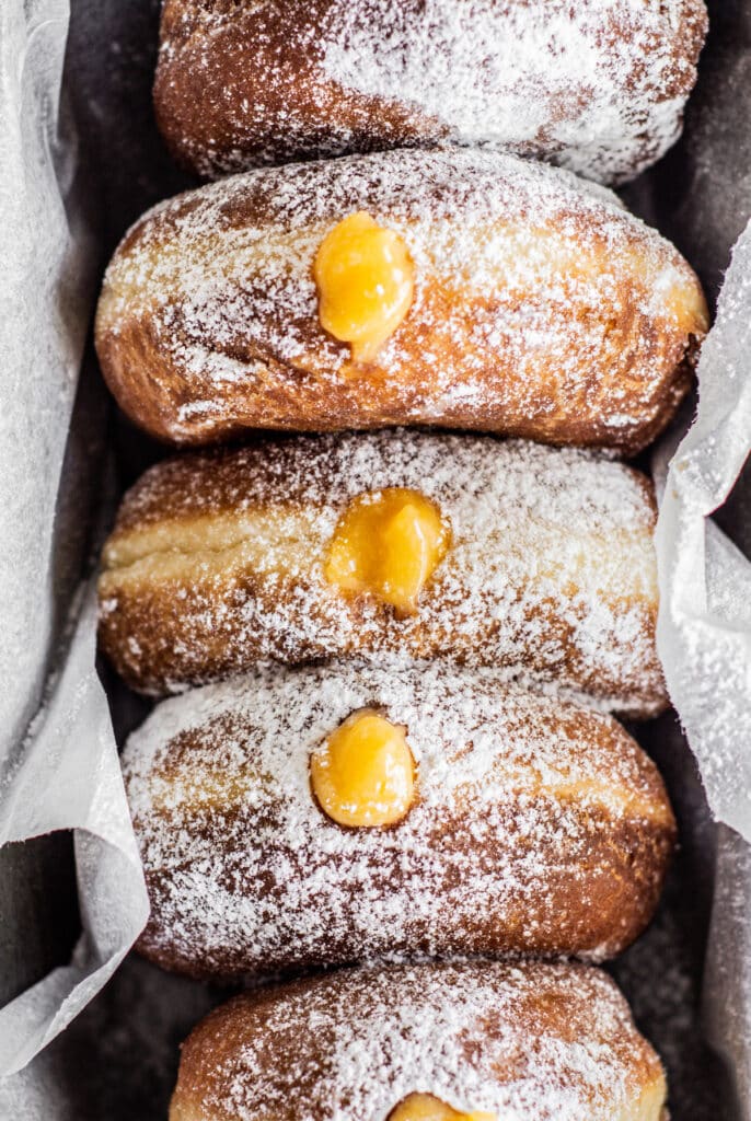 a close up of 4 lemon curd filled donuts.