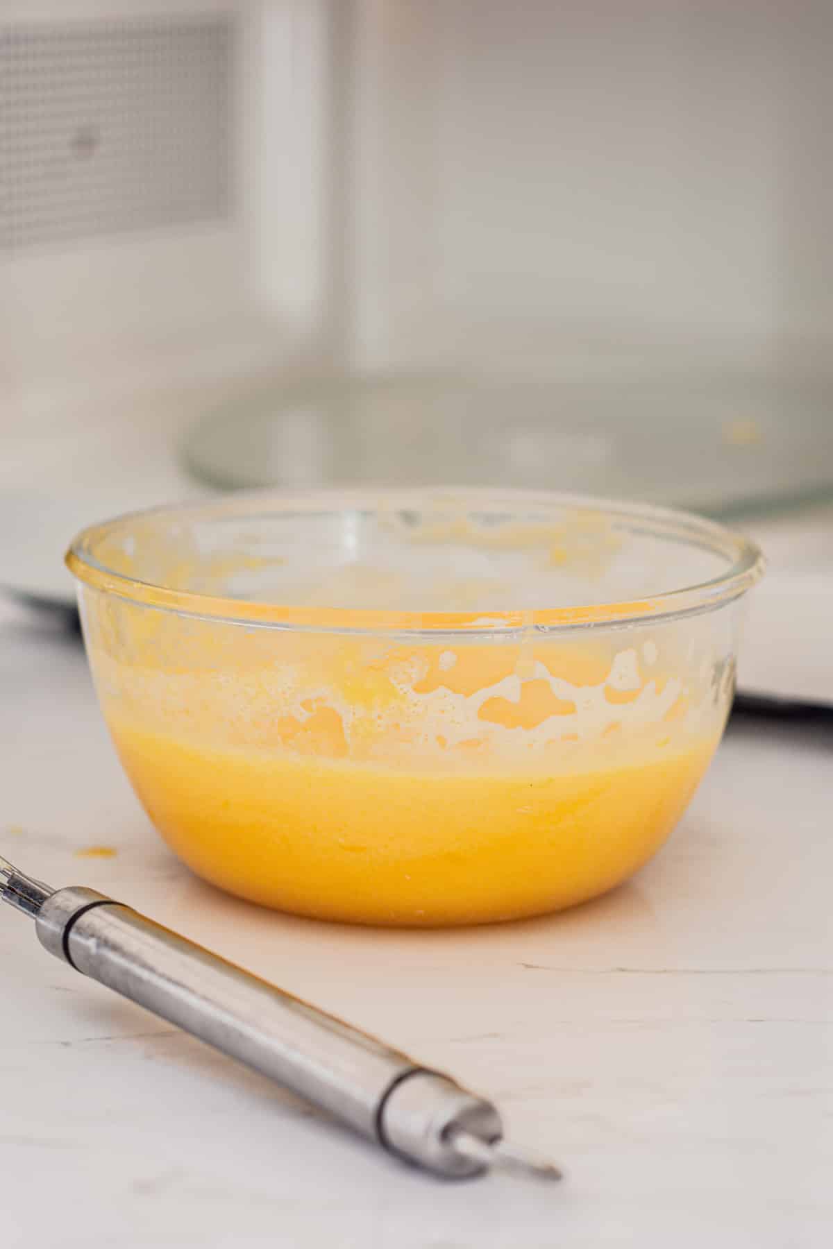 lemon curd in a bowl next to a microwave.