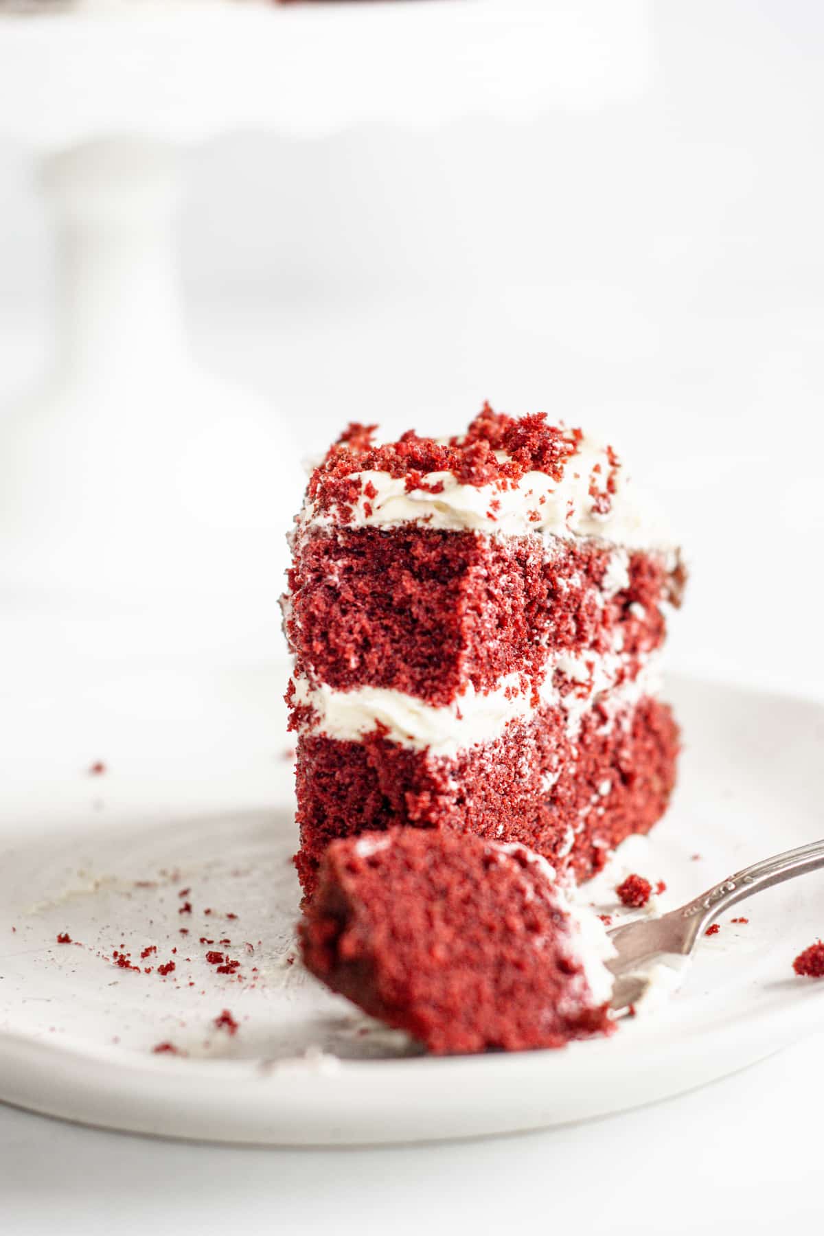 an upright slice of red cake with a fork,