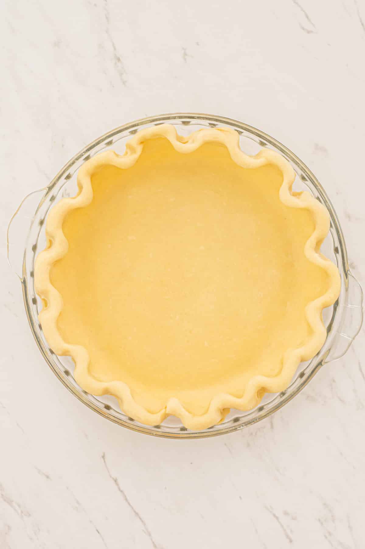 a pie dish with unbaked pastry in it.