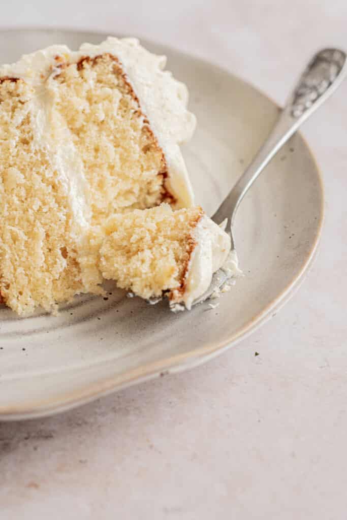 a slice of vanilla cake with a forkful.