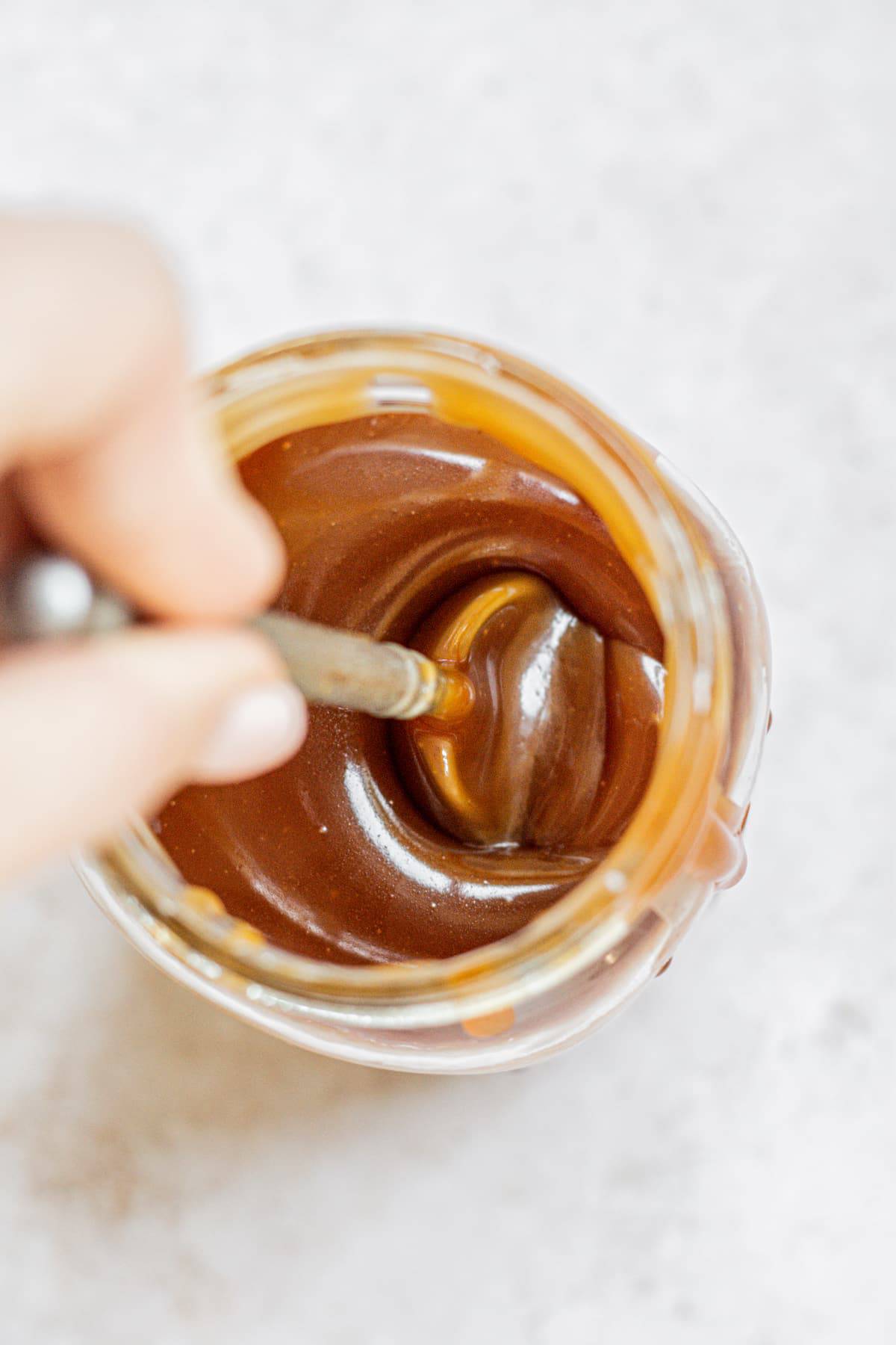 a spoon dipped into caramel.