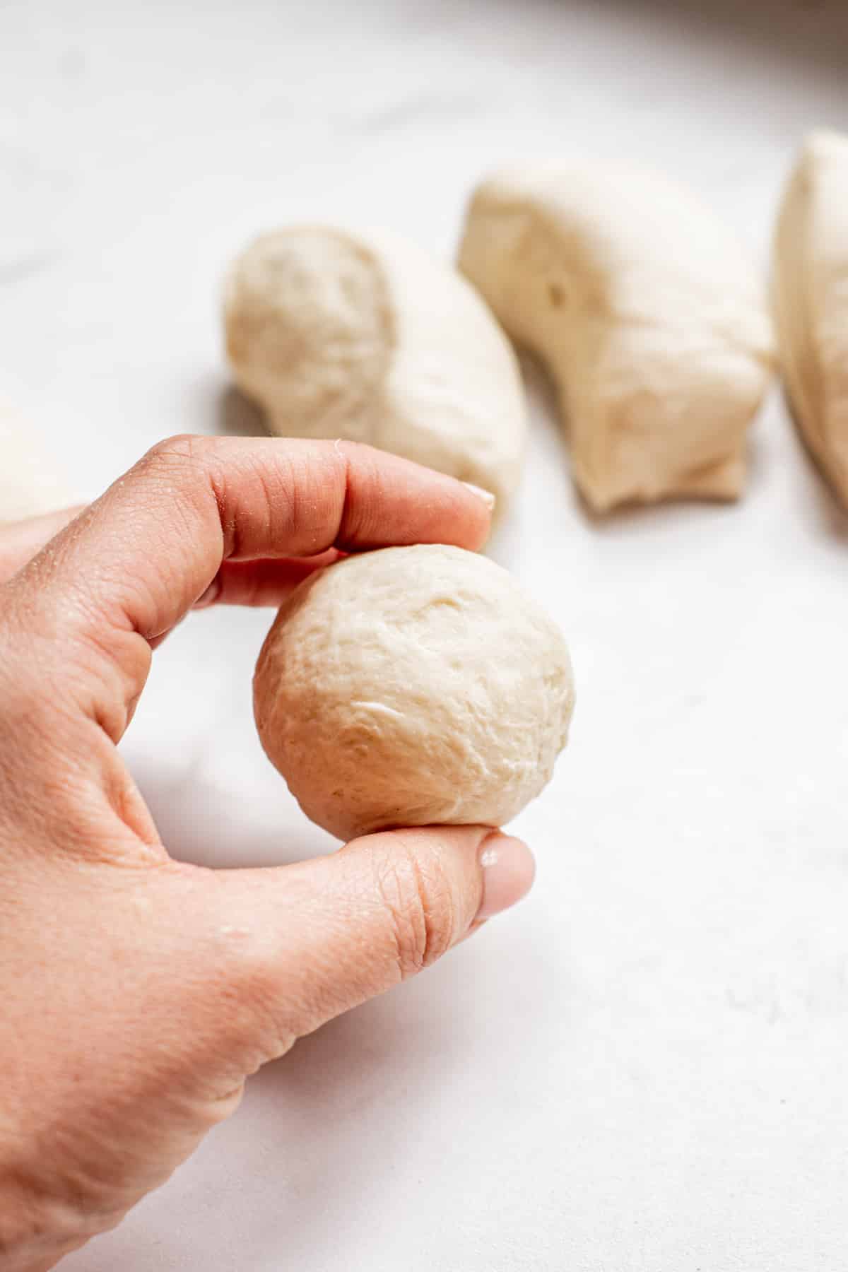 a hand holding a dough ball.