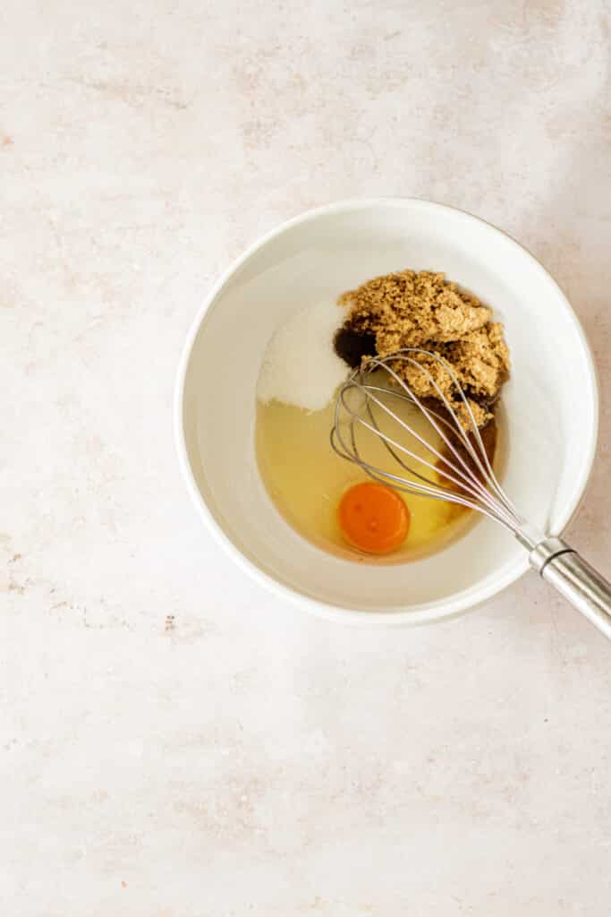 eggs sugar and vanilla in a bowl.