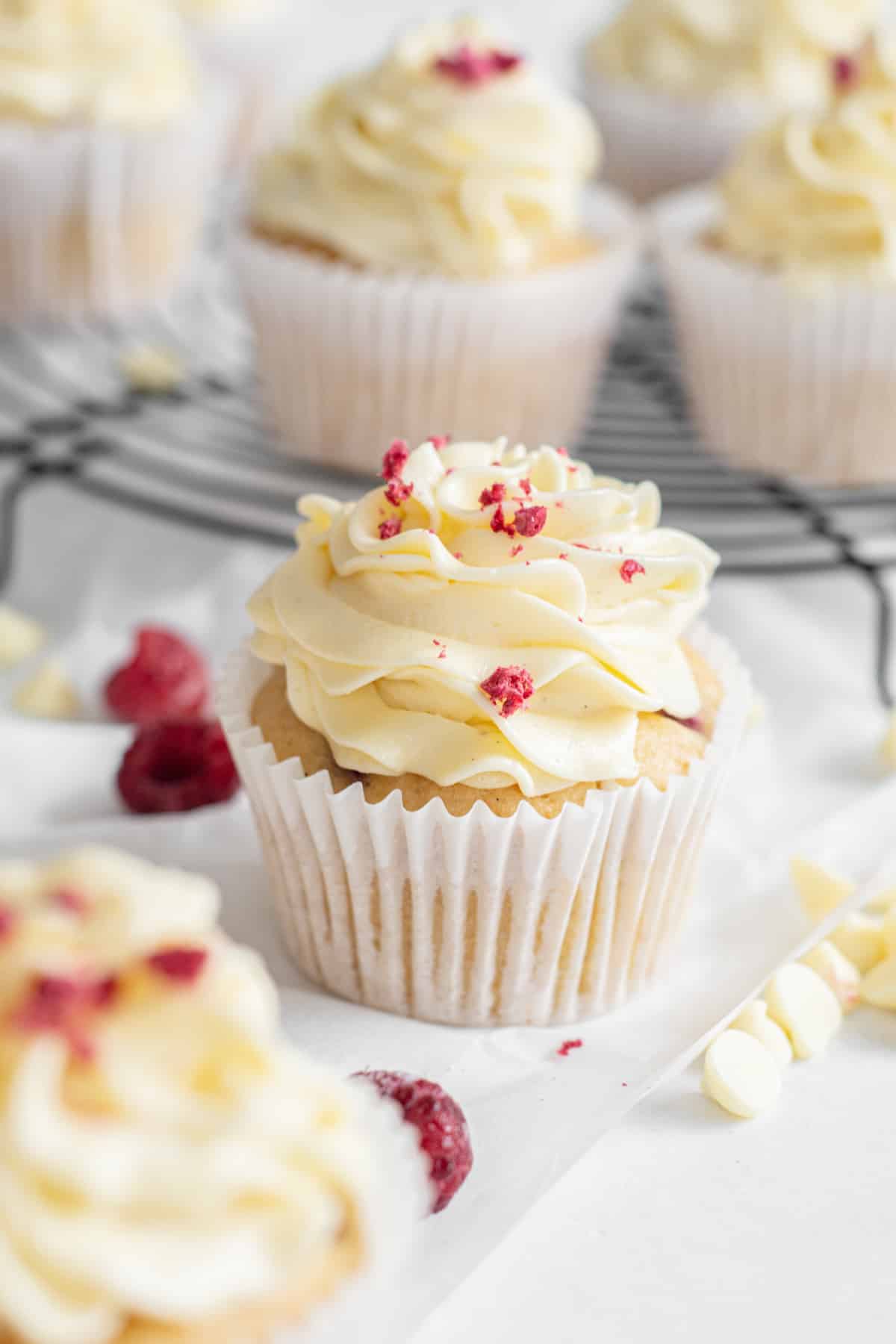 raspberry white chocolate cupcakes with bits of red raspberry on it.