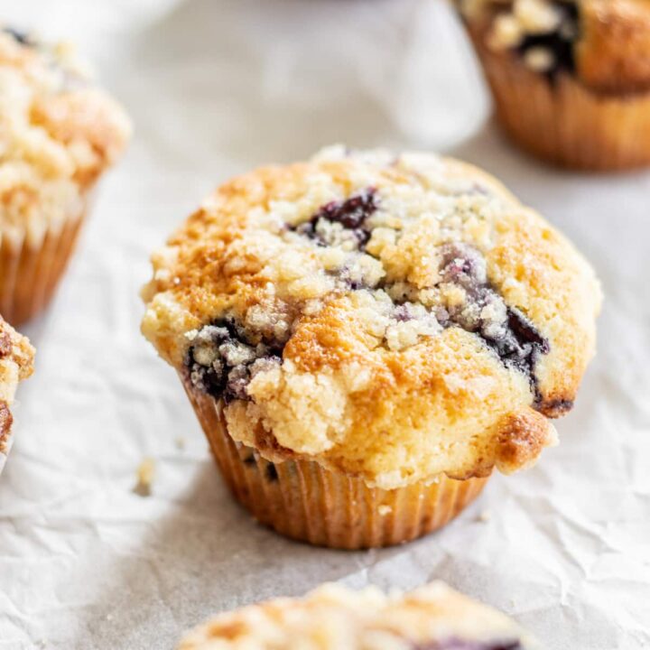 blueberry crumb muffins on parchment paper.