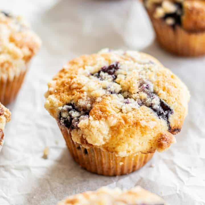 blueberry crumb muffins on parchment paper.