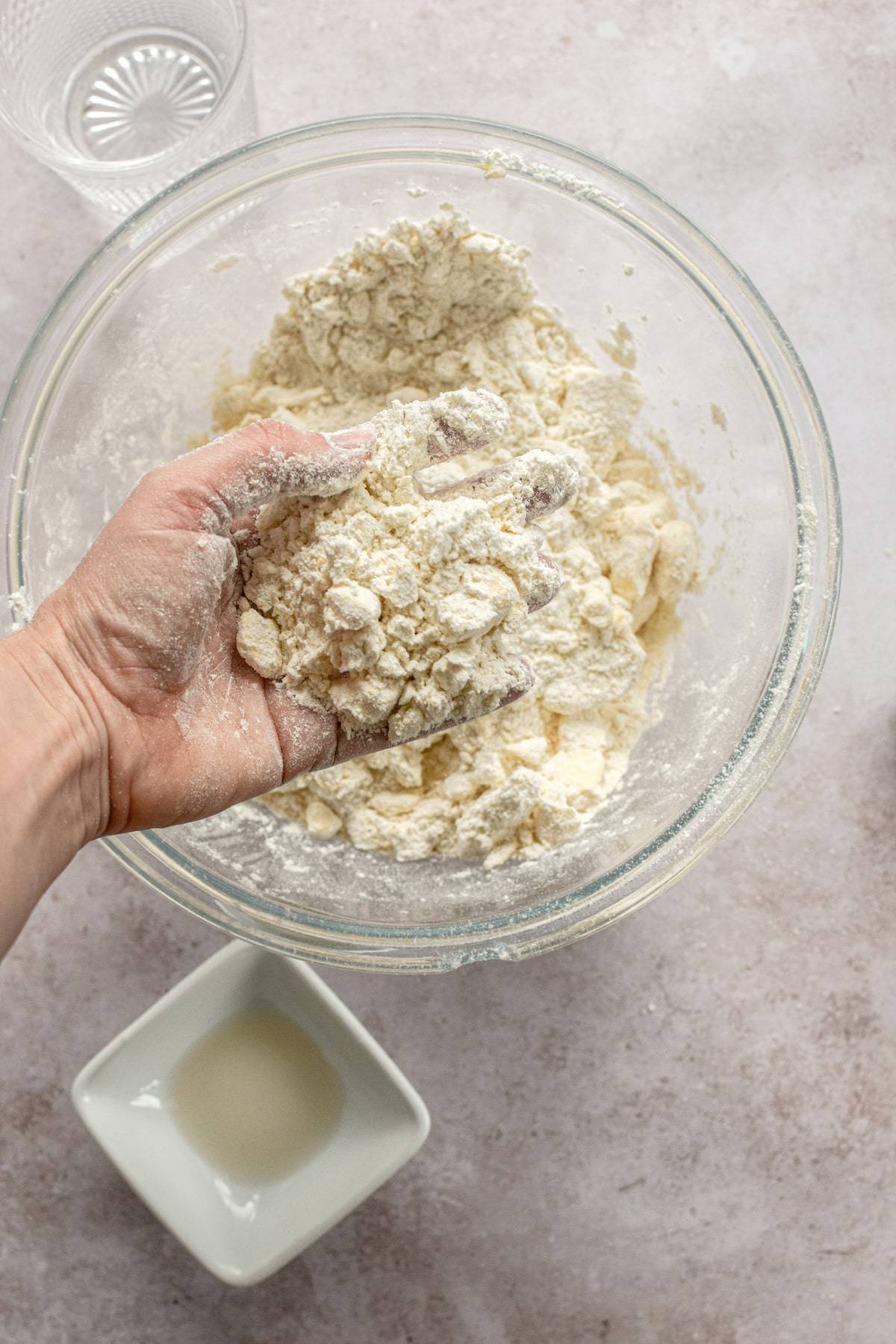 a hand holding butter and flour crumbles.