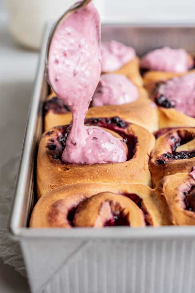 frosting being dolloped on rolls.