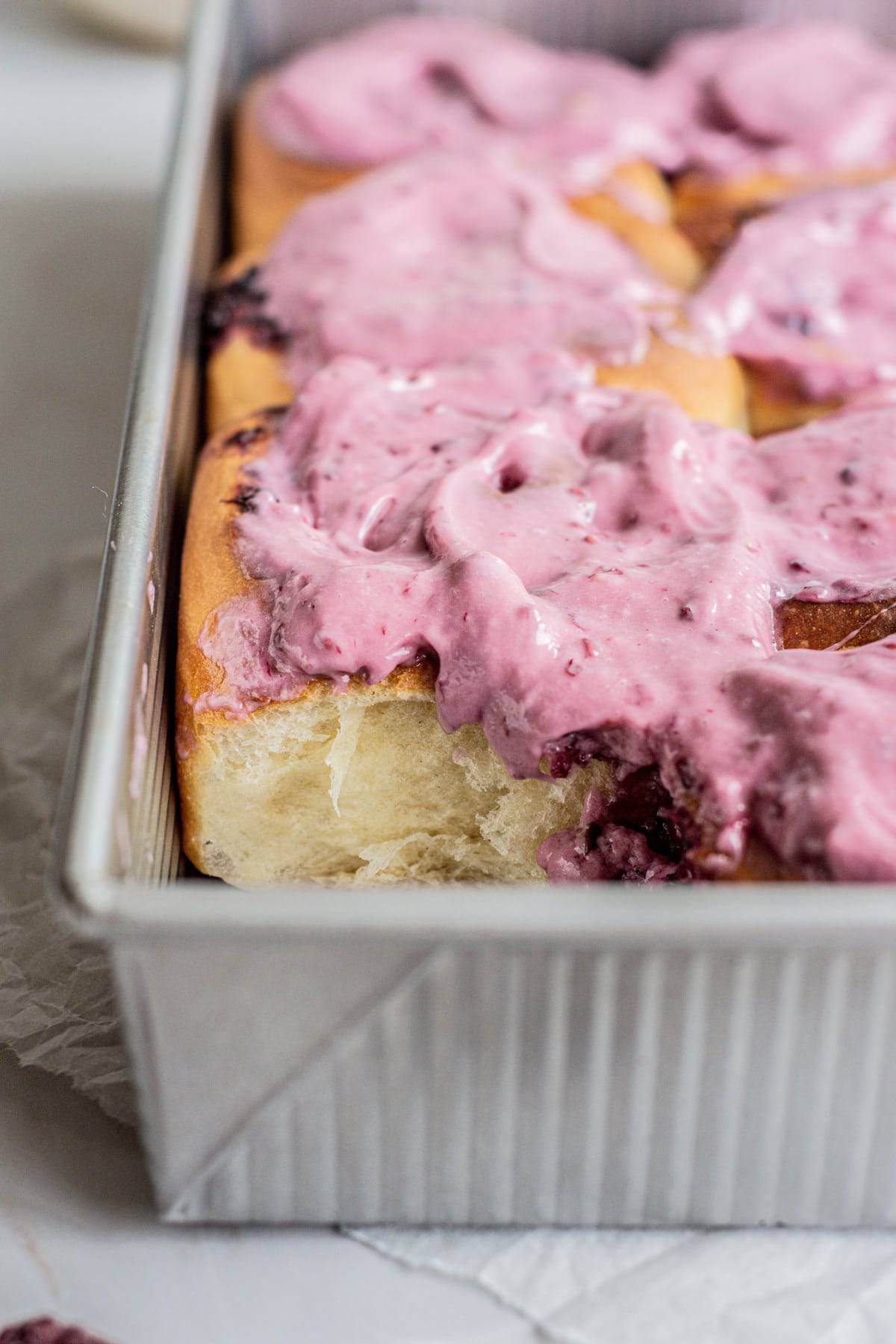 close up of frosted blackberry buns.