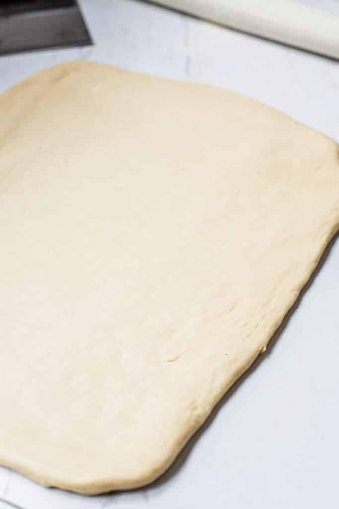 a dough rectangle on a white bench.