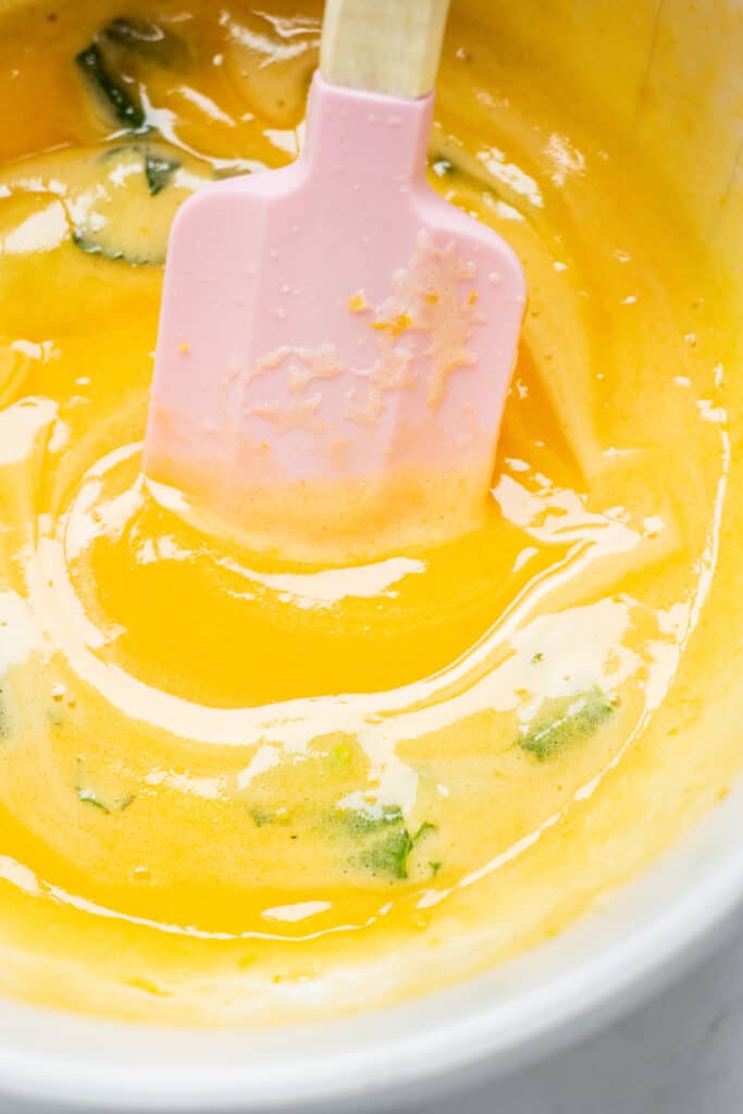 a pink spatula in yellow curd.