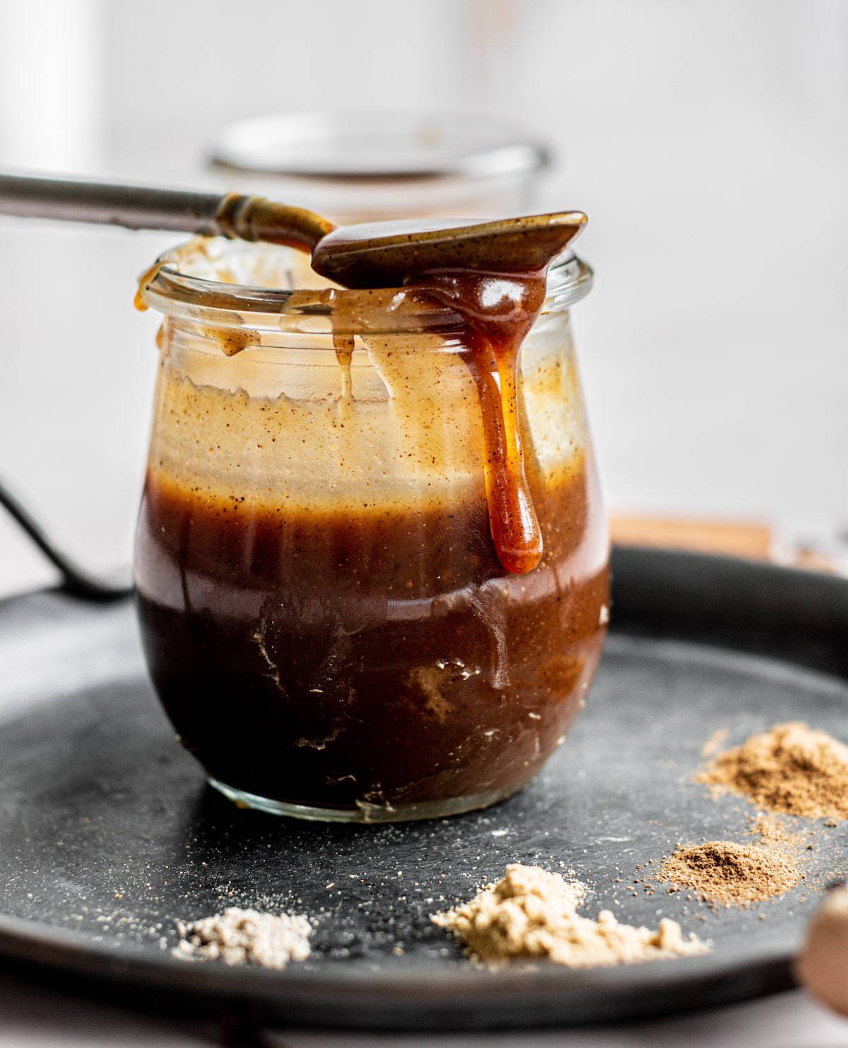 caramel dripping off a spoon on a jar.