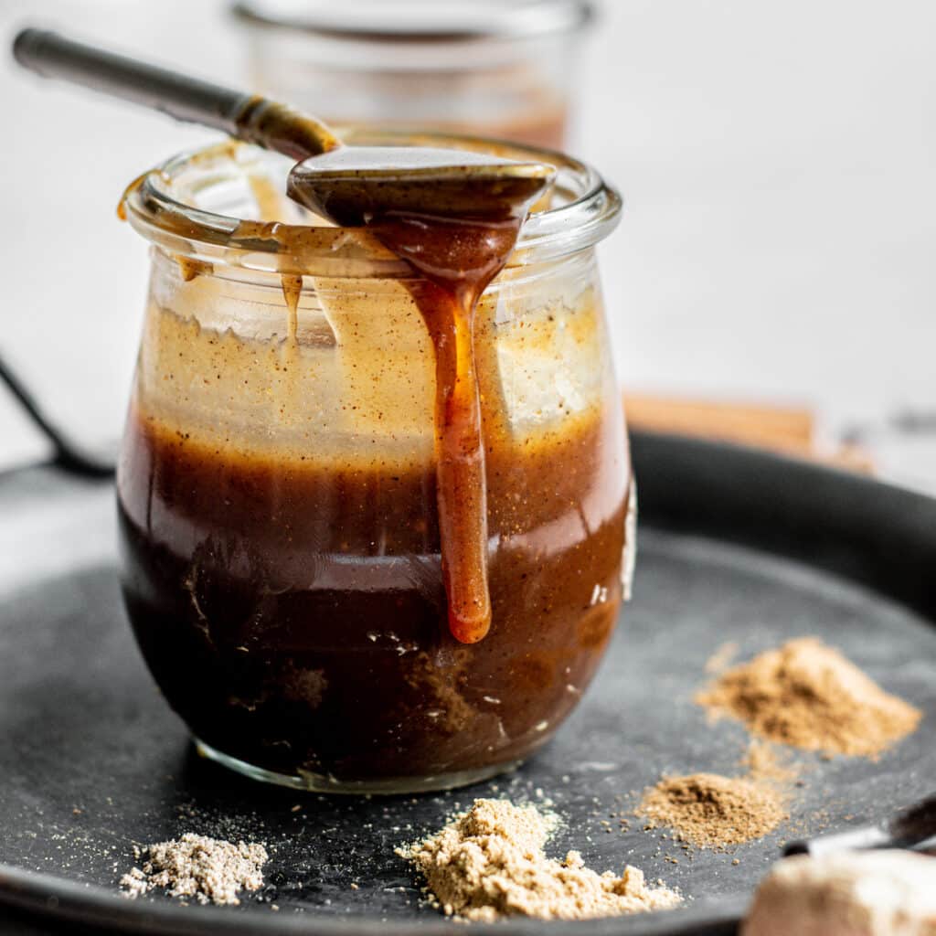 caramel dripping off a spoon on a jar.