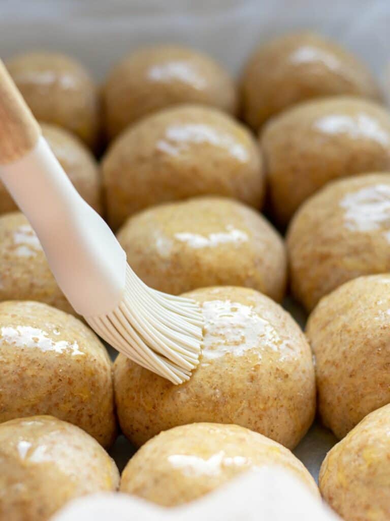 dough balls being brushed with butter,