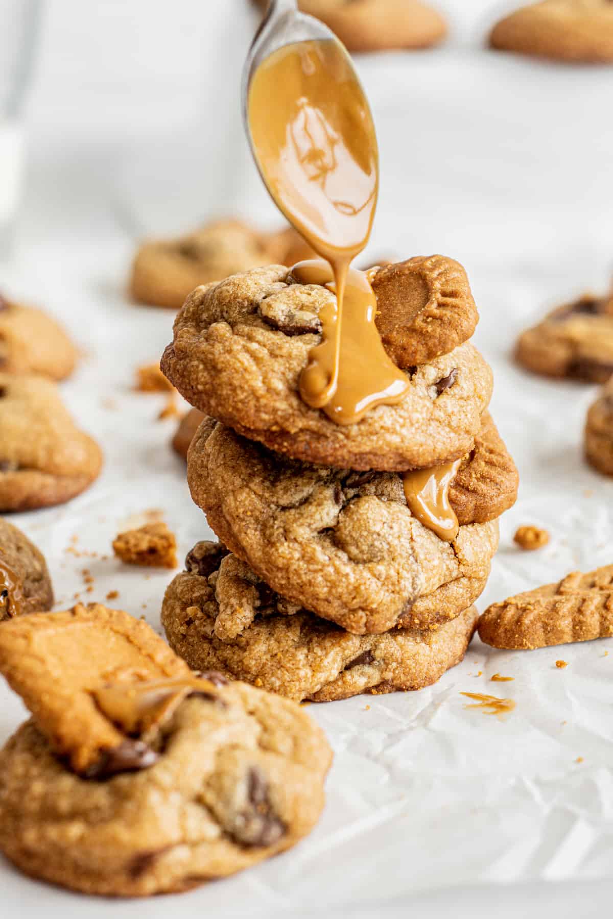a spoon drizzling cookie butter on cookies.