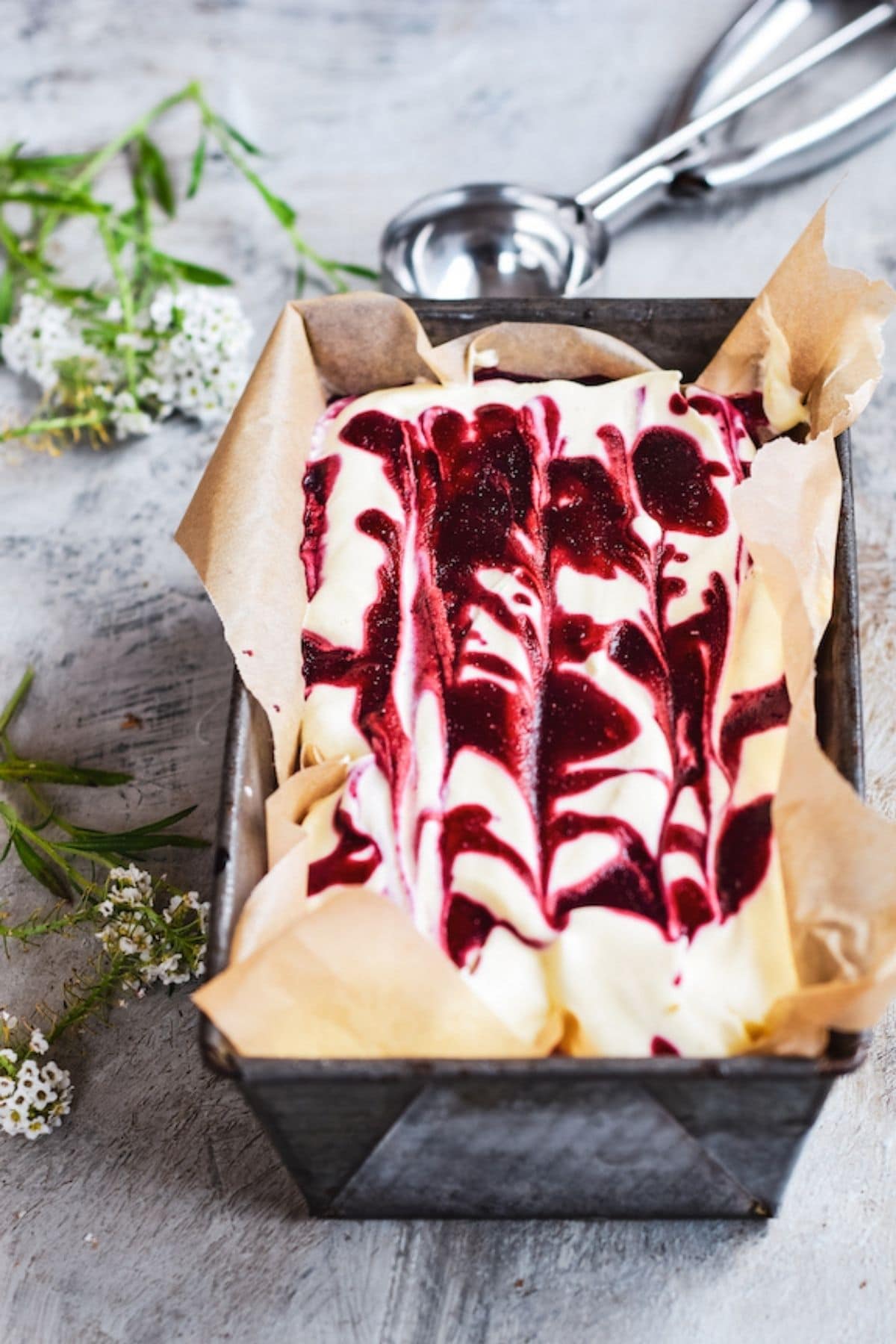 a pan of ice cream with berry swirls.