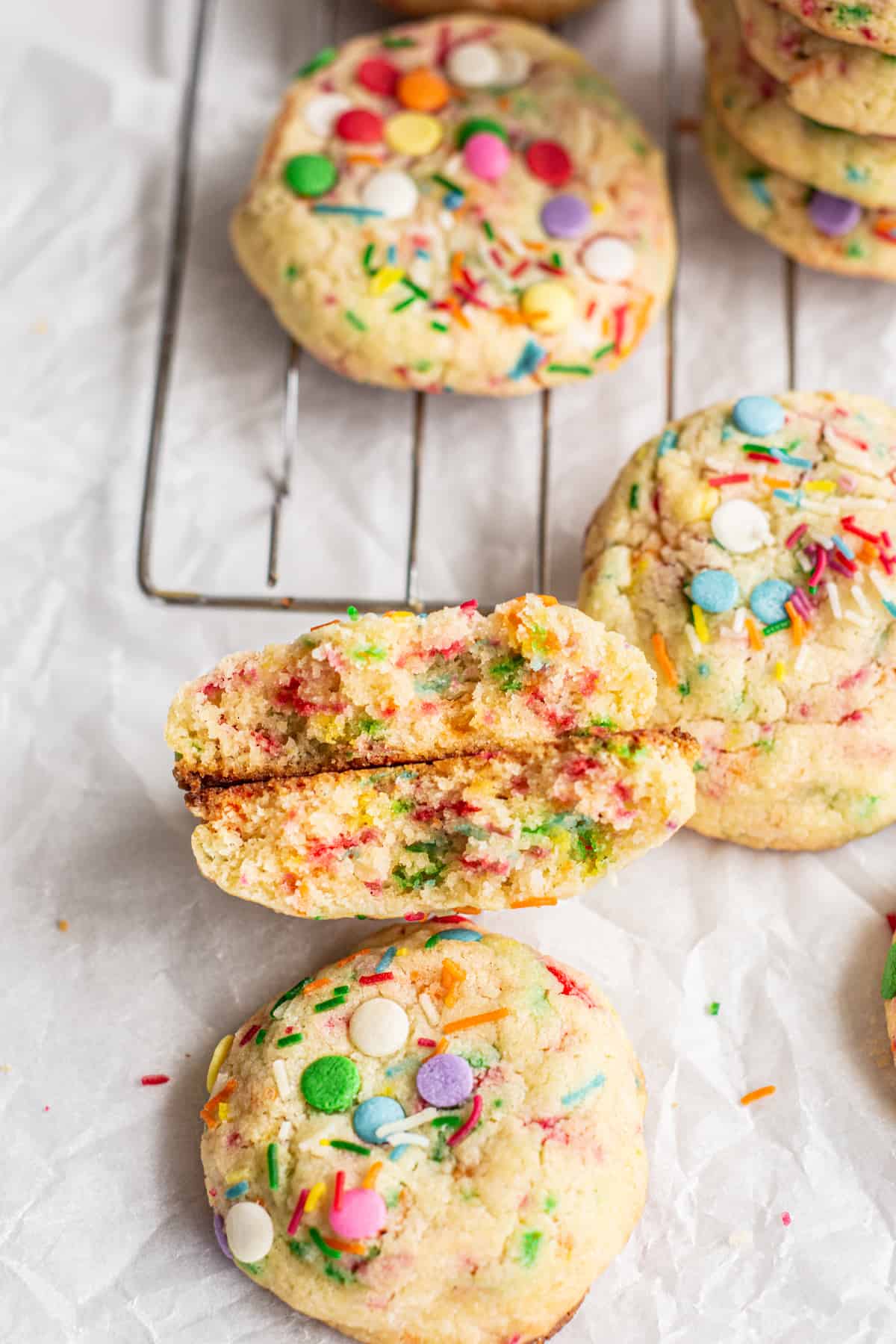 sprinkle cookies in the background, havled cookie in the forefront.