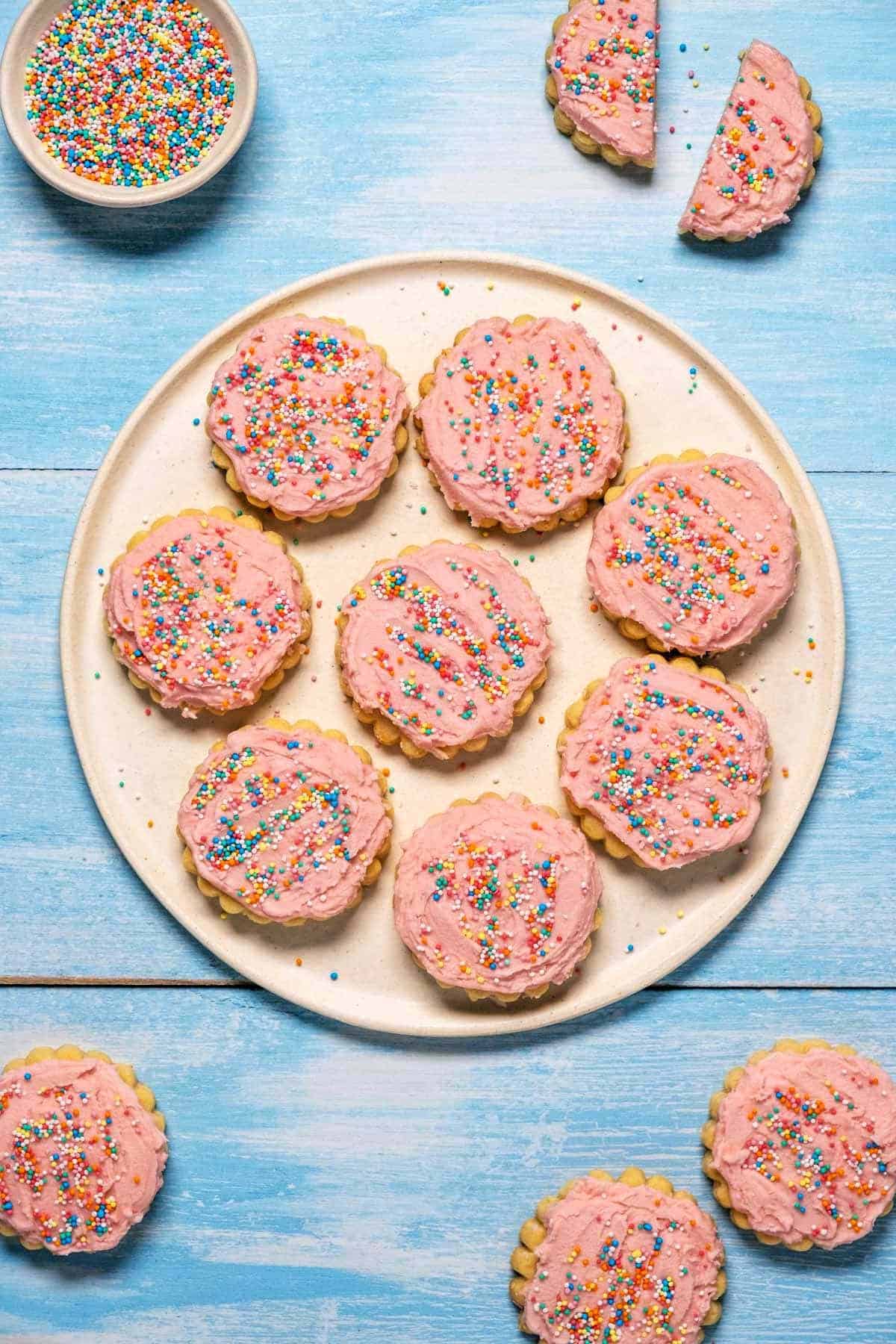 birds eye view of pink icing and sprinkle covered cookies.