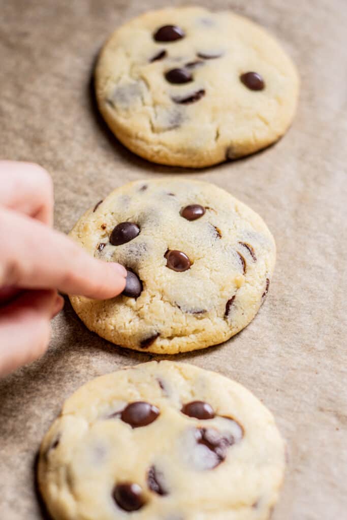 chocolate chip being pressed into a cookie.