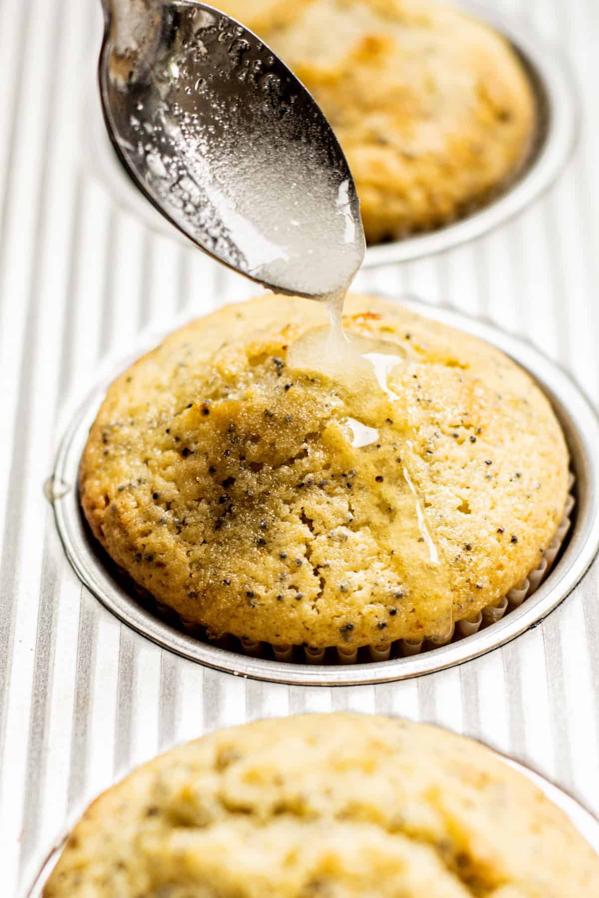 syrup being drizzled onto a muffin.