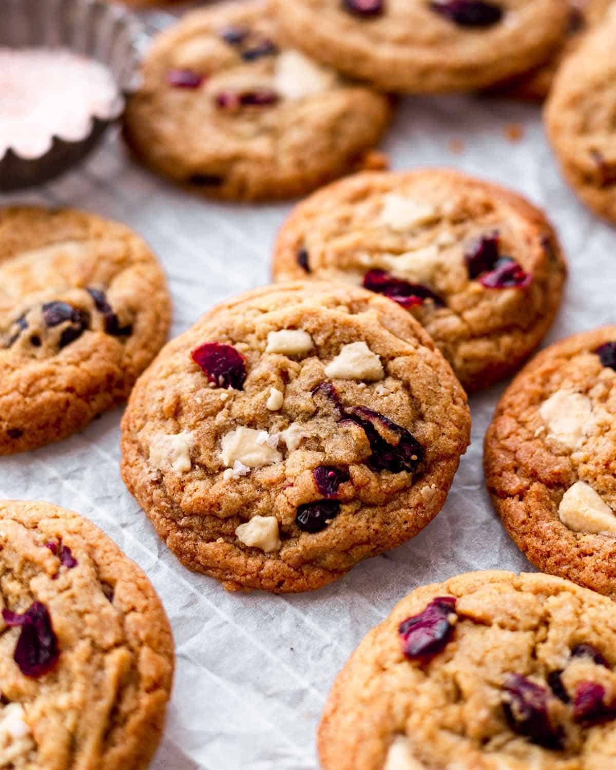 cranberry cookies with white chocolate on parchment paper.