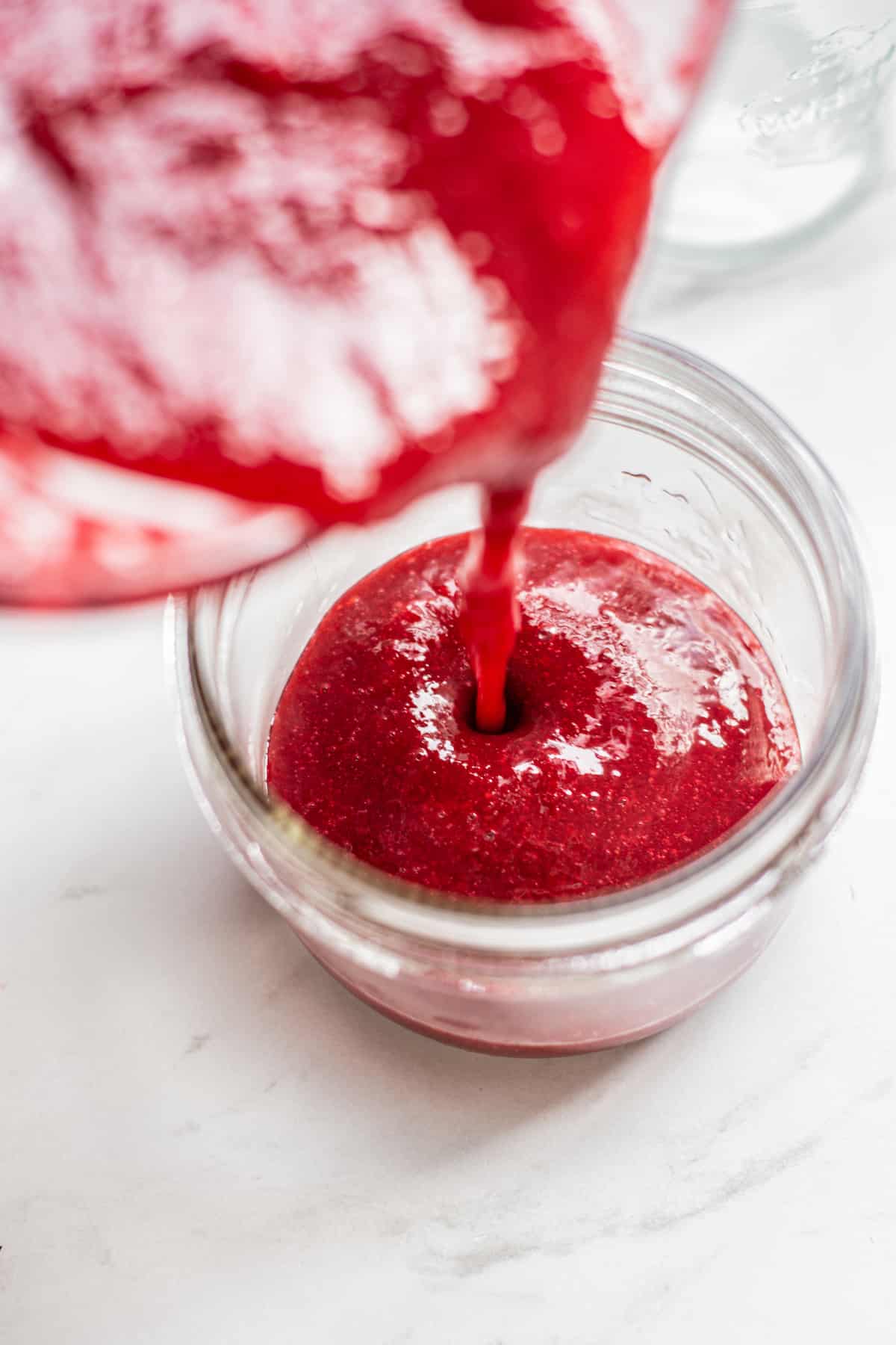raspberry sauce pouring into jar.