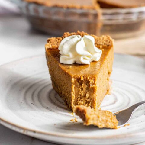 Slice of pumpkin pie with a forkful missing.