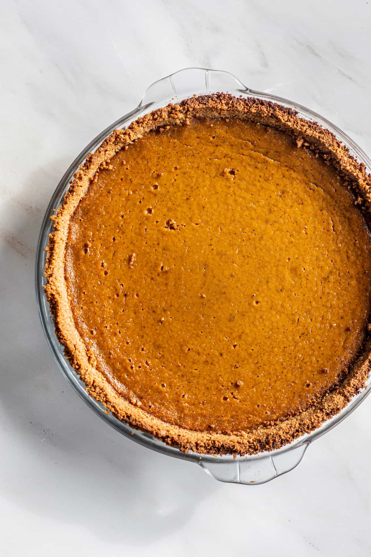a baked pumpkin pie with a graham cracker crust.