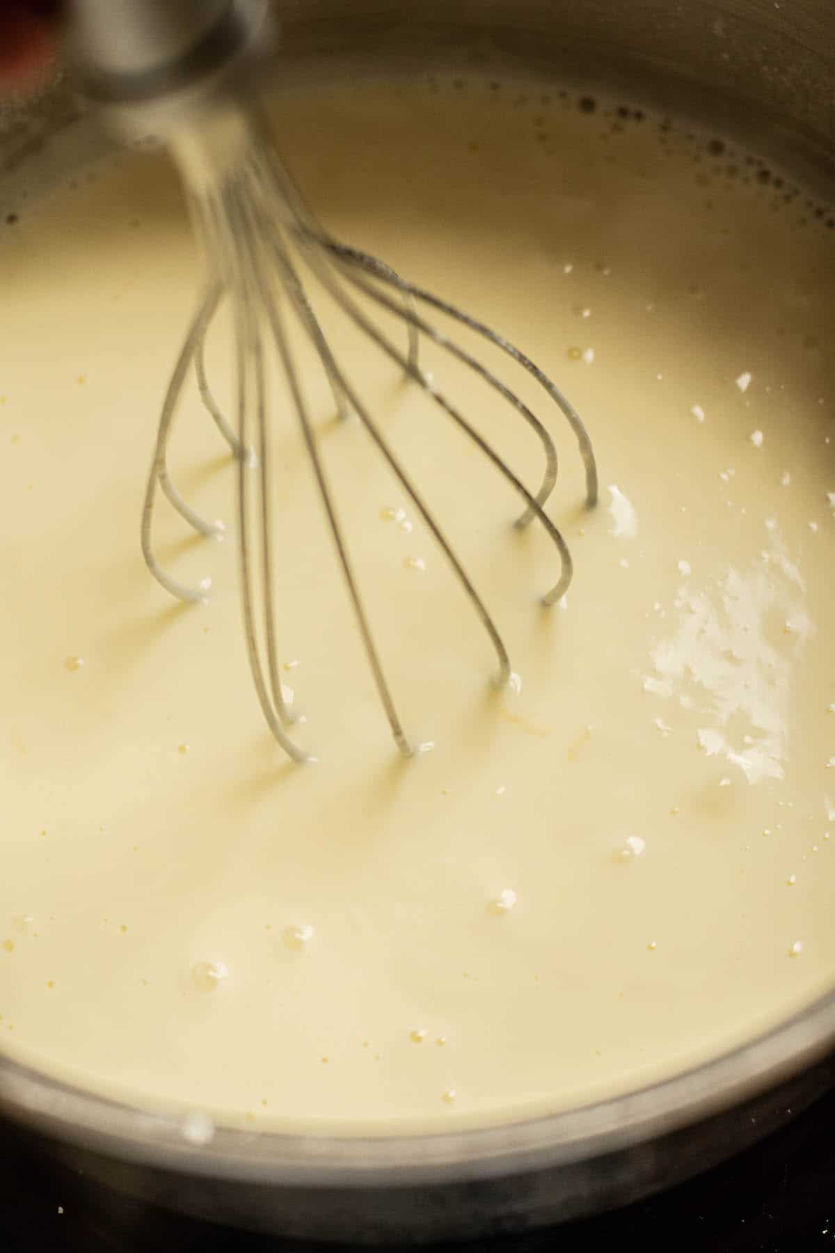 a whisk in a white mixture.