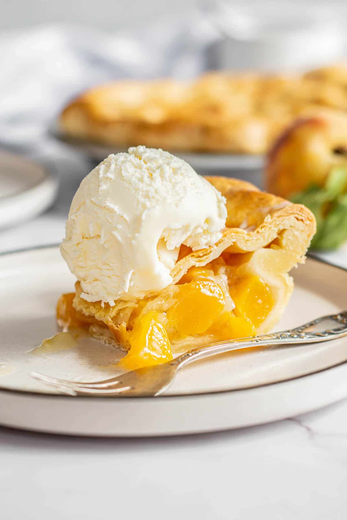 a slice of peach with a scoop of ice cream.