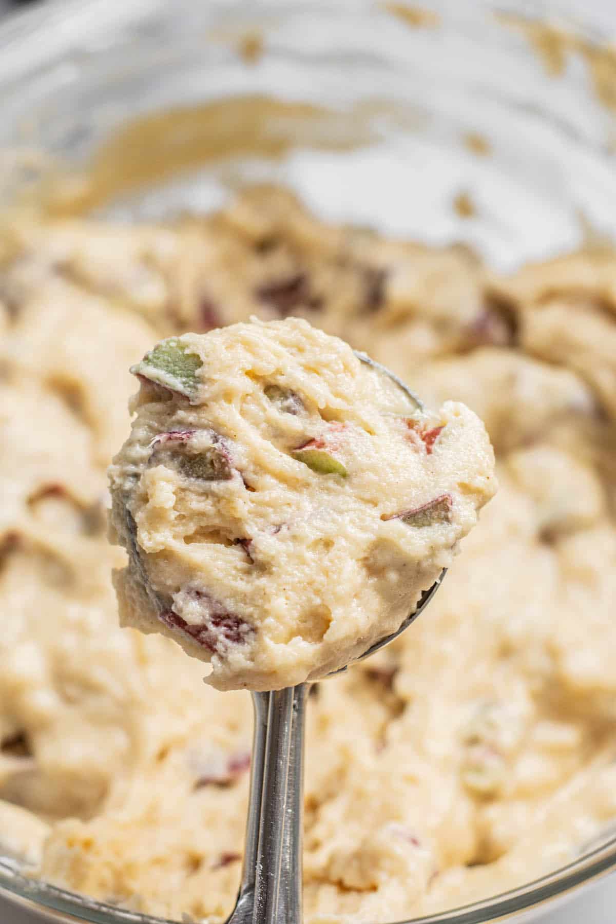 a scoop of muffin batter with rhubarb pieces.