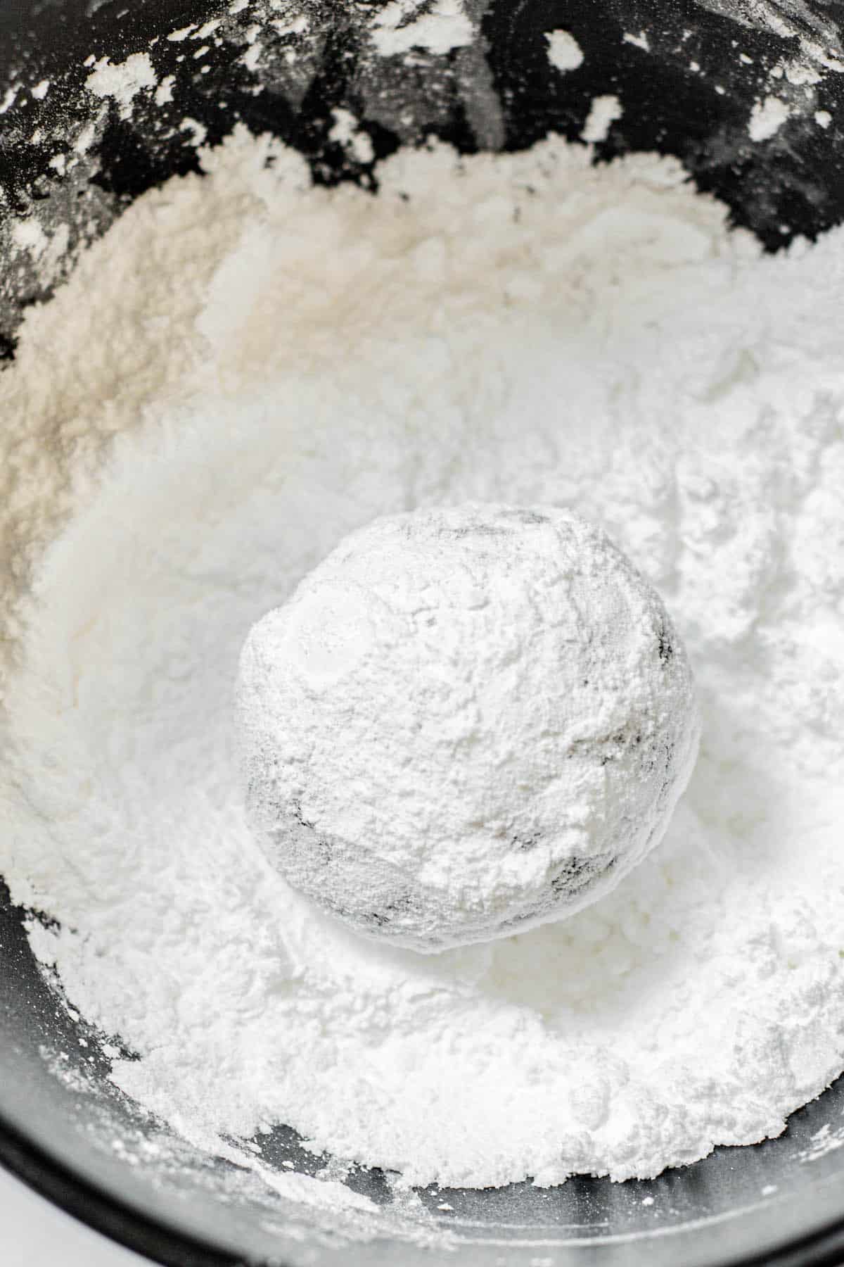 ball of dough in powdered sugar.