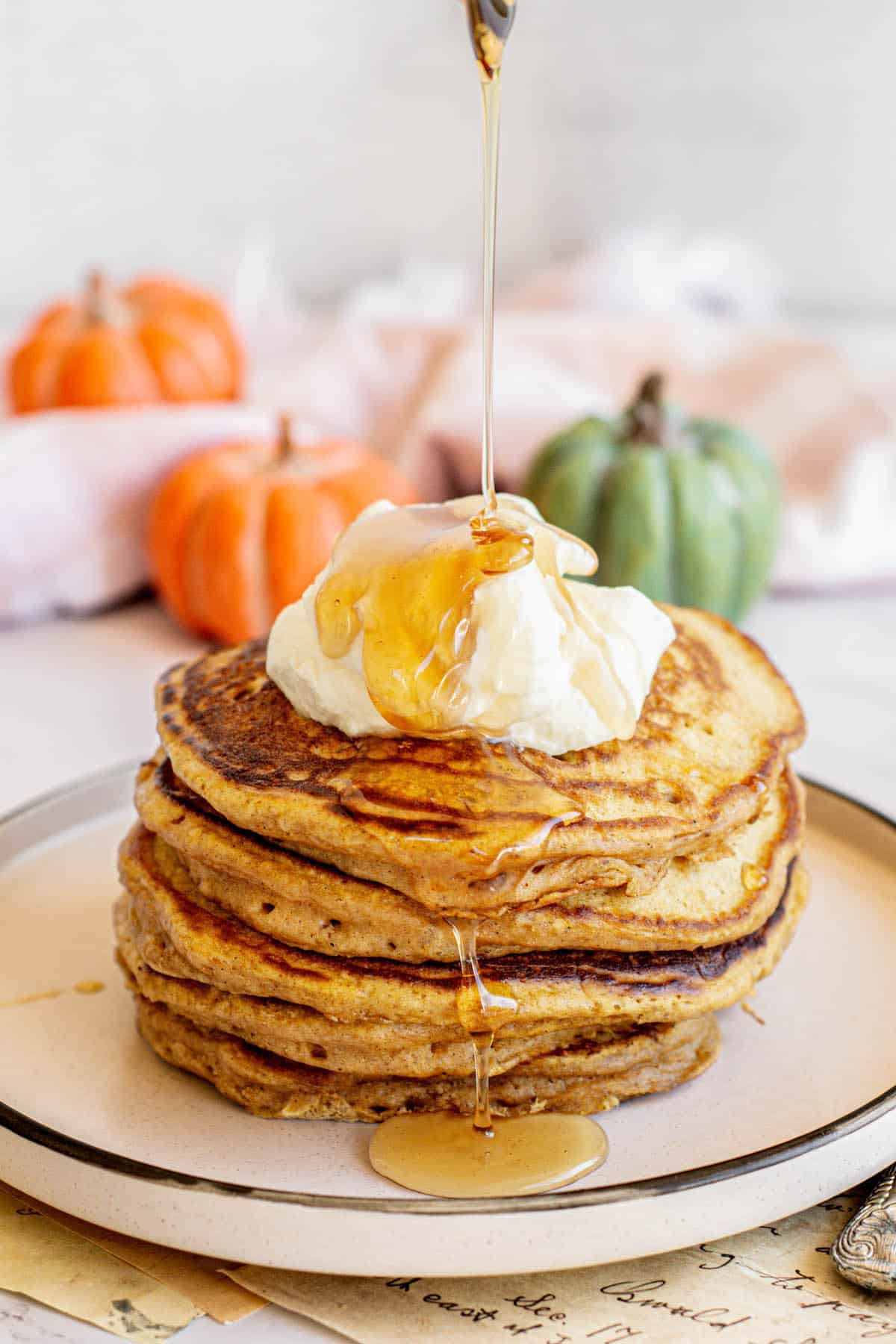 a stack of maple syrup drizzled sourdough pumpkin pancakes