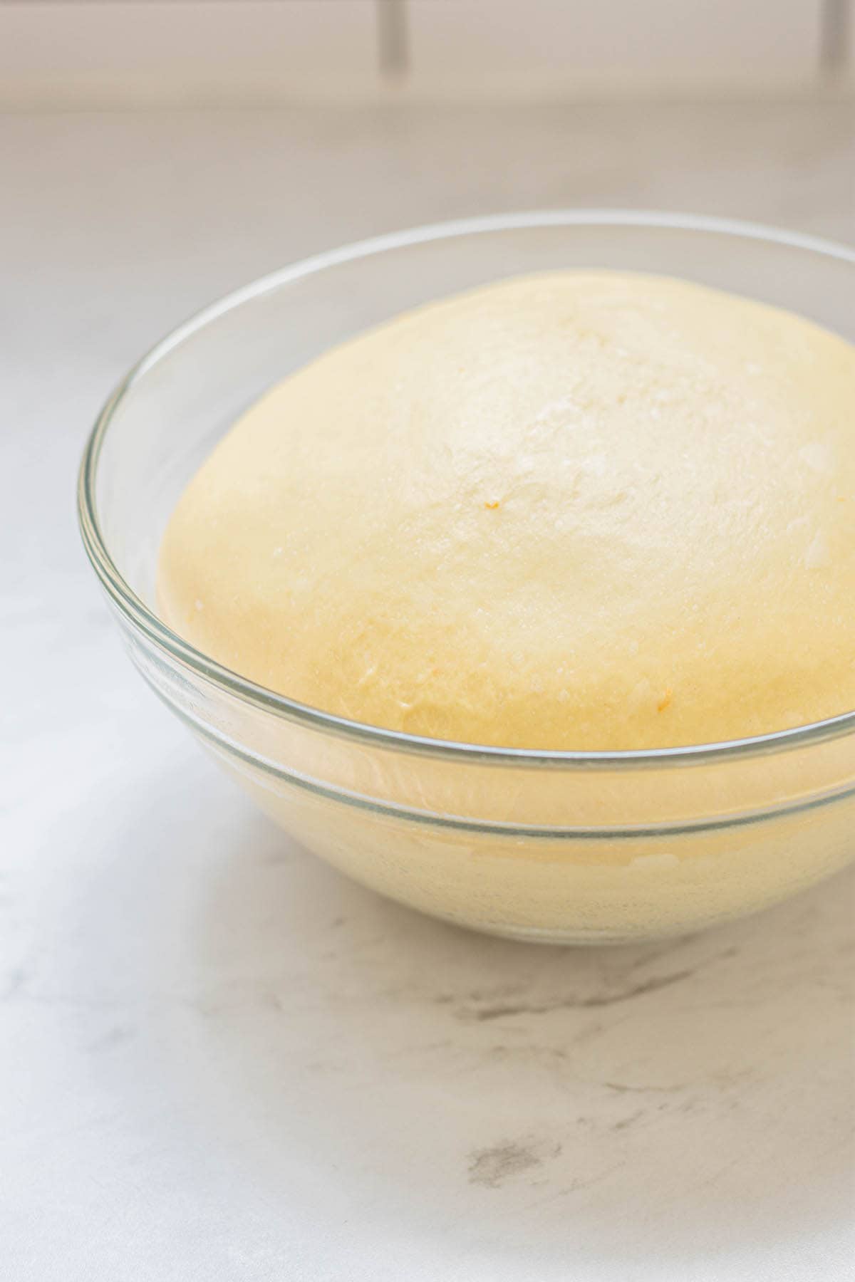 risen dough in glass bowl.