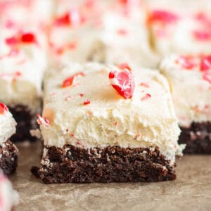 Close up of candy cane brownies, with thick layer of white frosting and crushed candy canes.