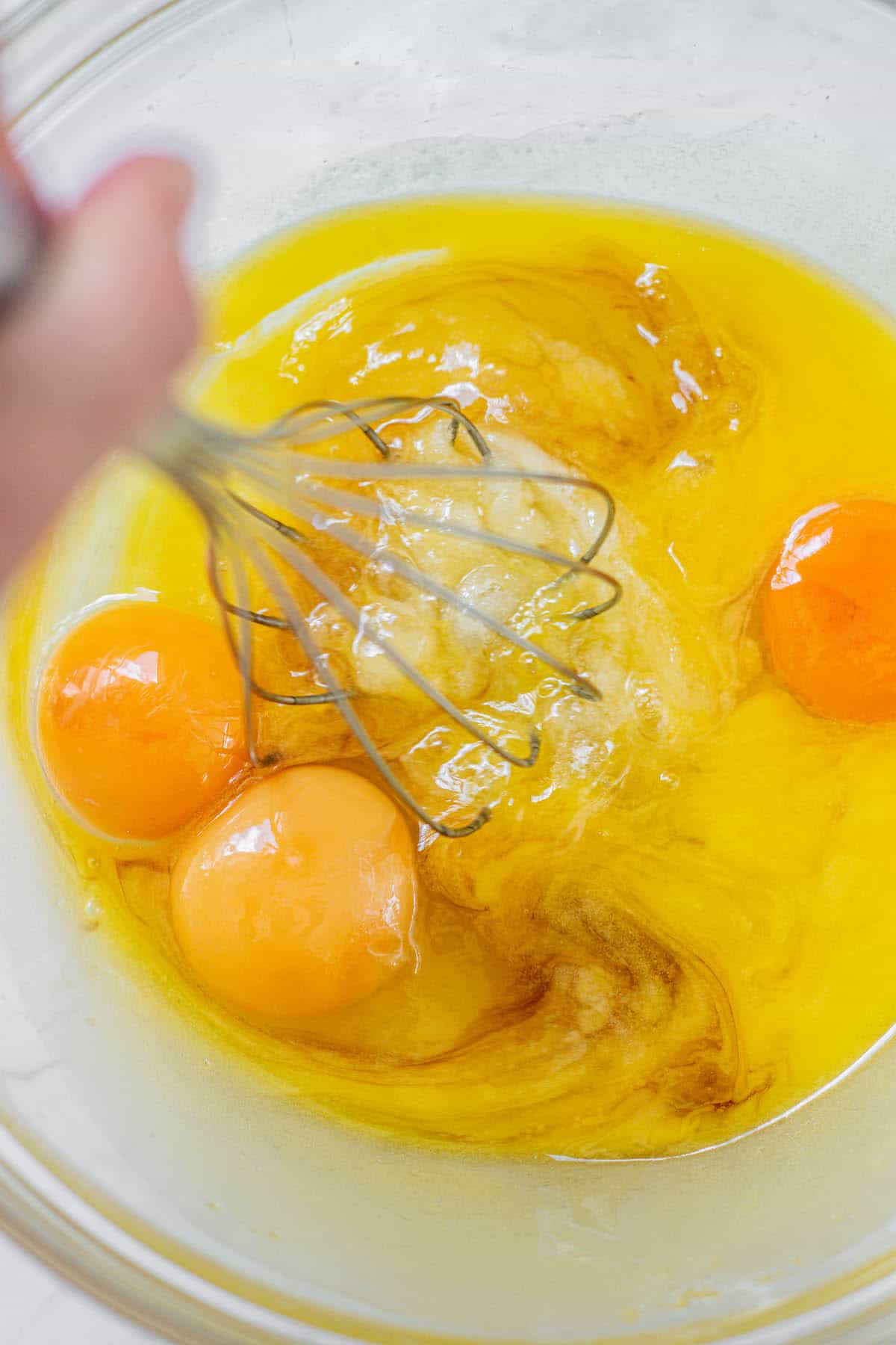 eggs and sugar and melted butter being whisked.