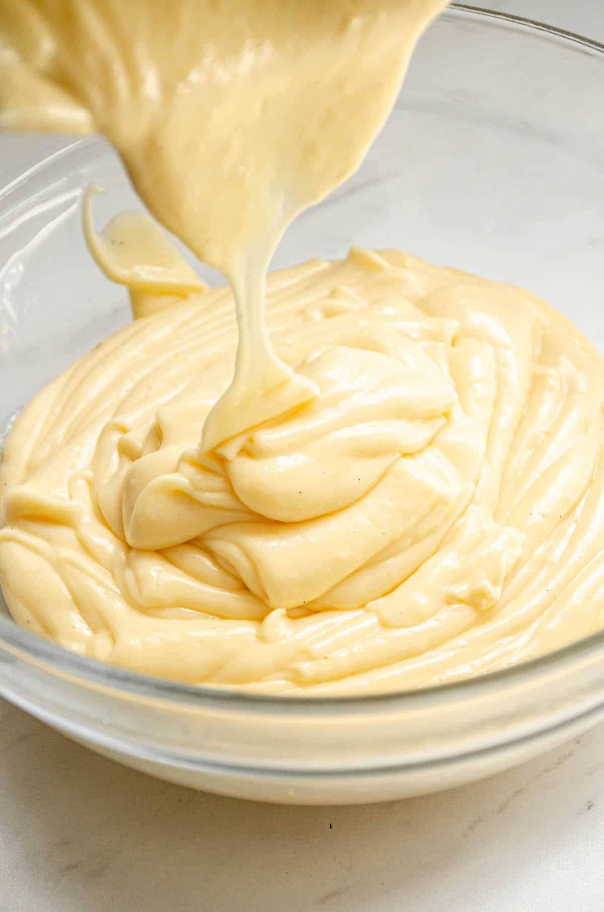 thick custard being poured into a bowl.