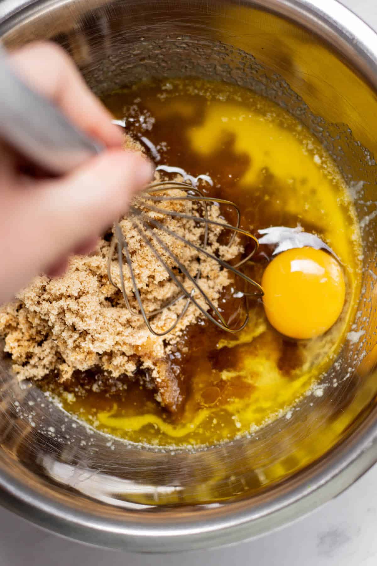 egg, brown sugar and butter in a silver bowl.